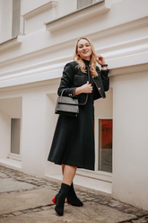 a lady in a black jacket and a black skirt